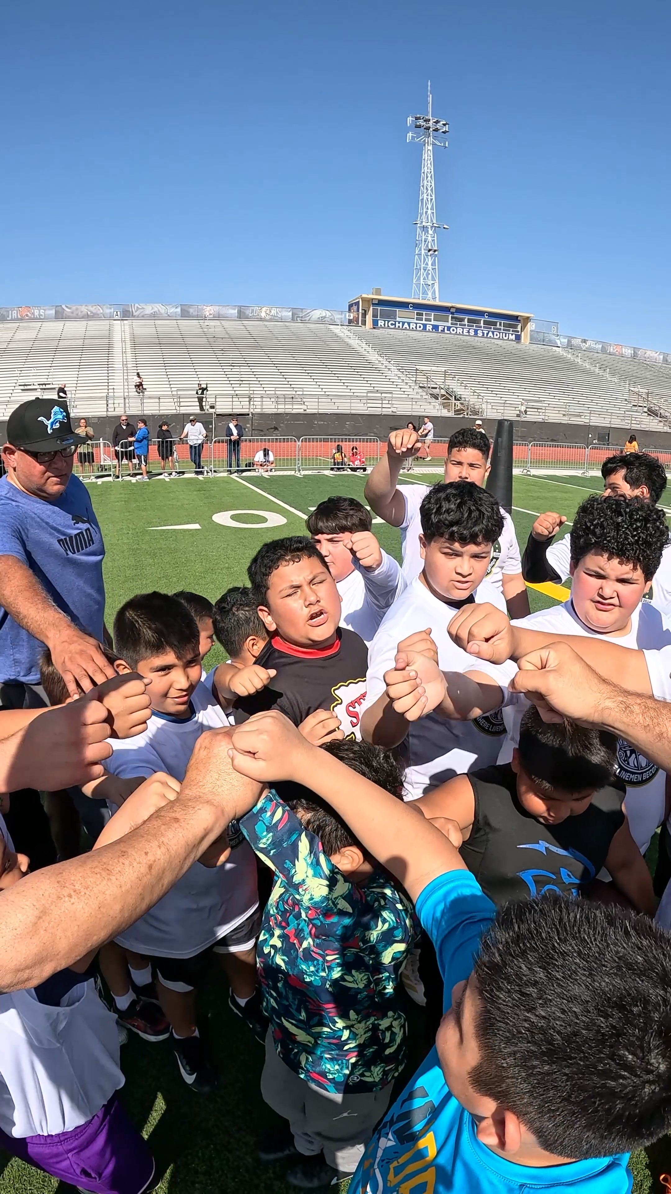 Young football players gathering together in a team huddle