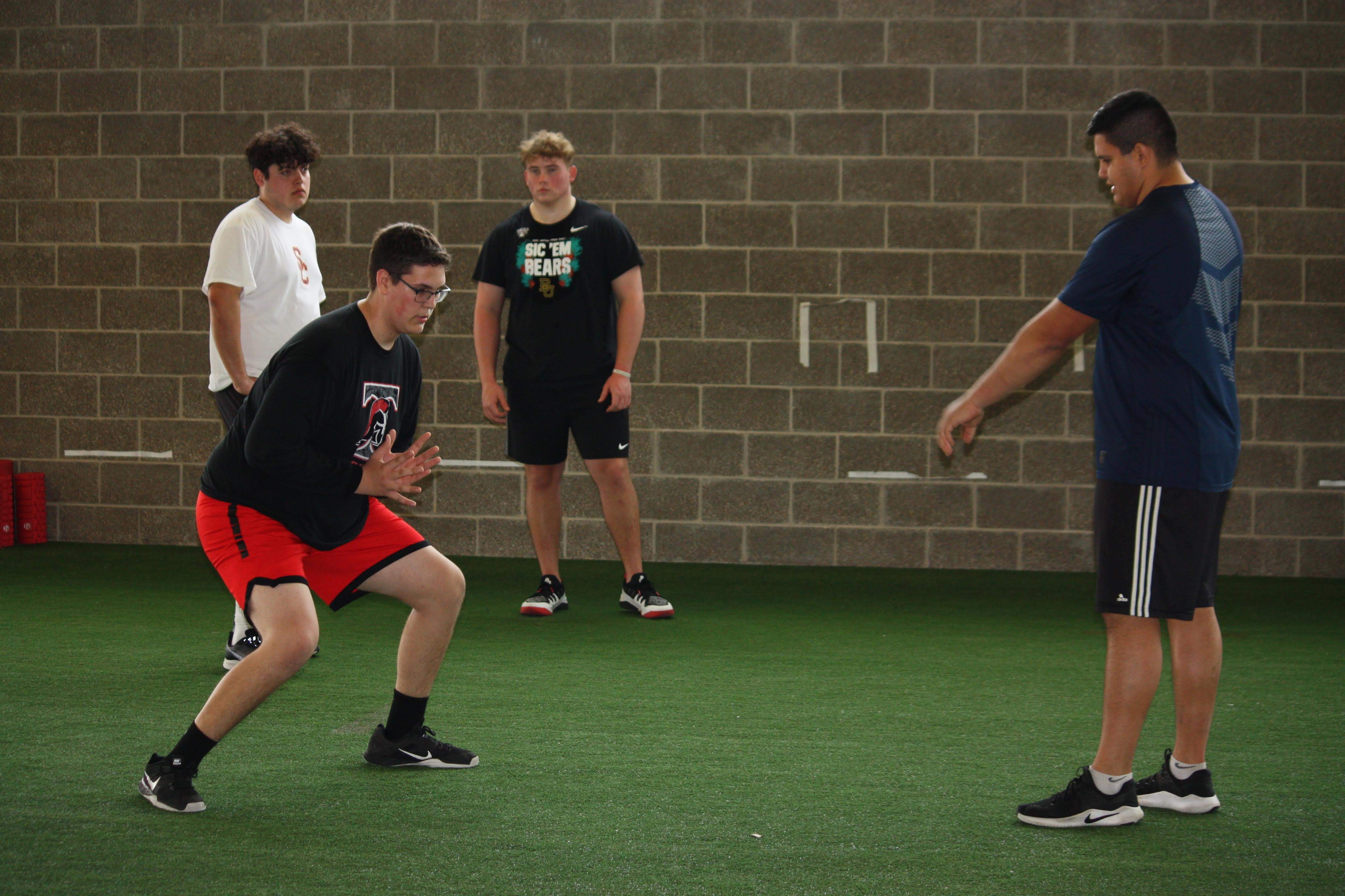 Young athlete practicing footwork with a coach in an indoor training space